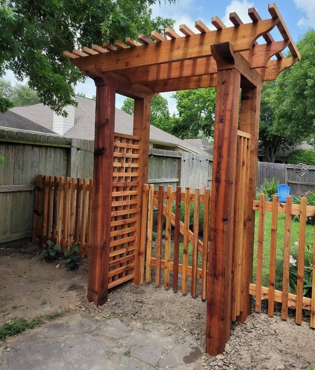 Cedar arbor gateway with stepped rafters and picket fence