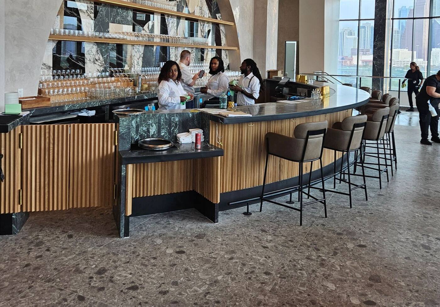 Finished hotel bar with fluted wood front, stools and staff