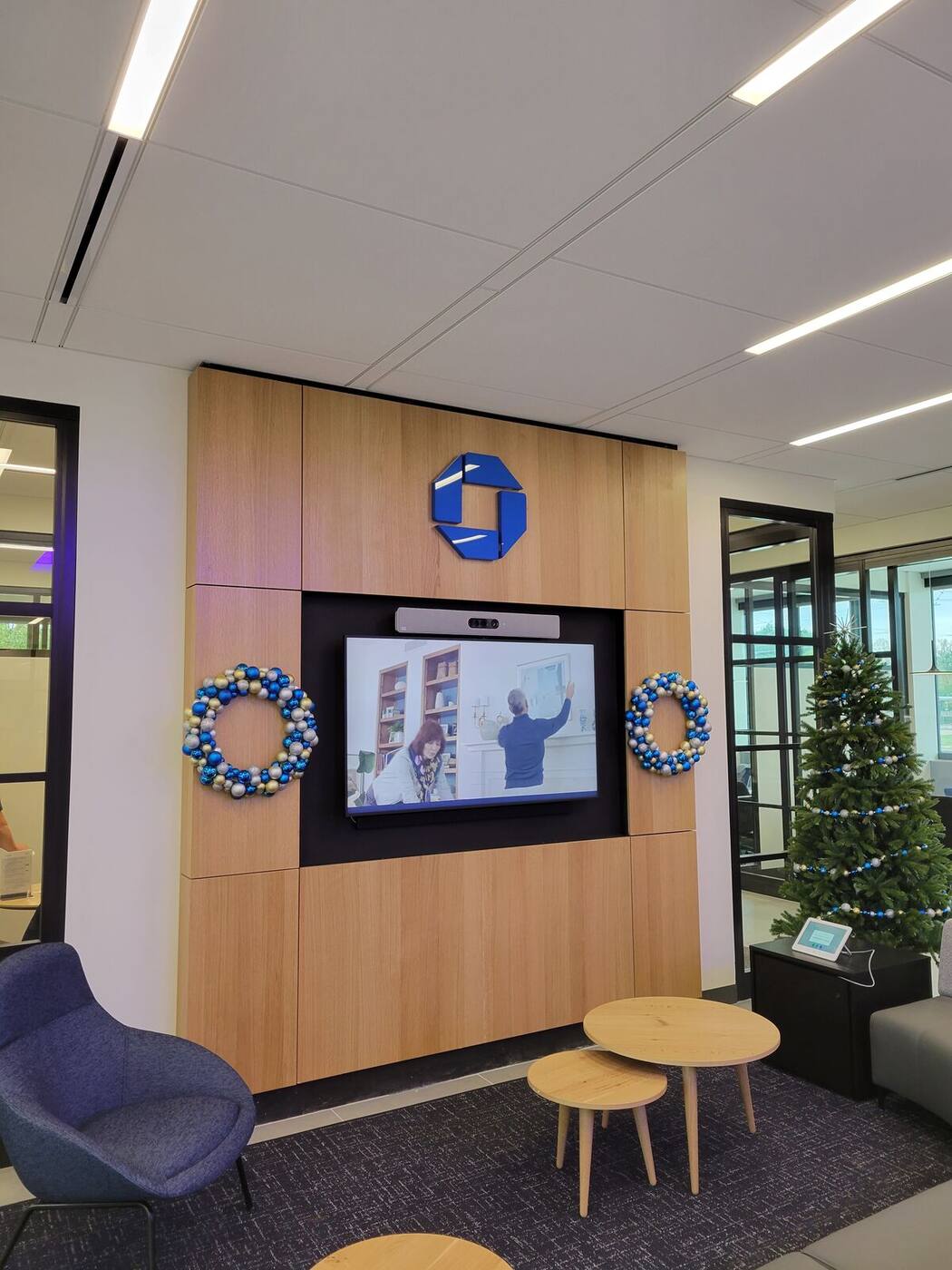 Wood media feature wall with recessed display in bank lounge