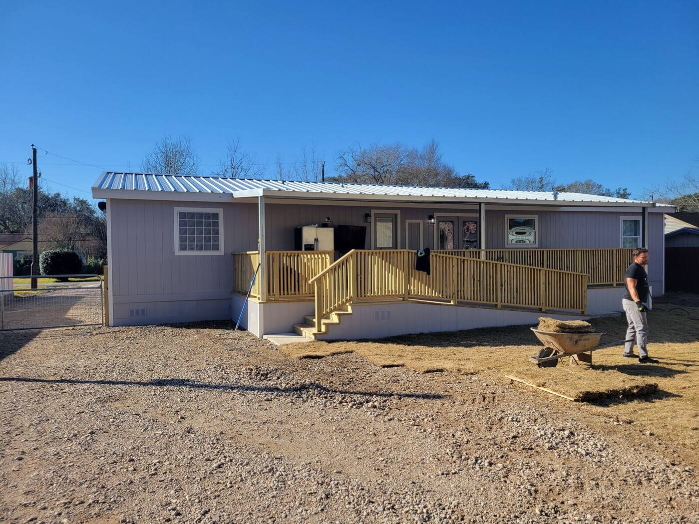 Wrap-around deck and railing on gray home with stairs