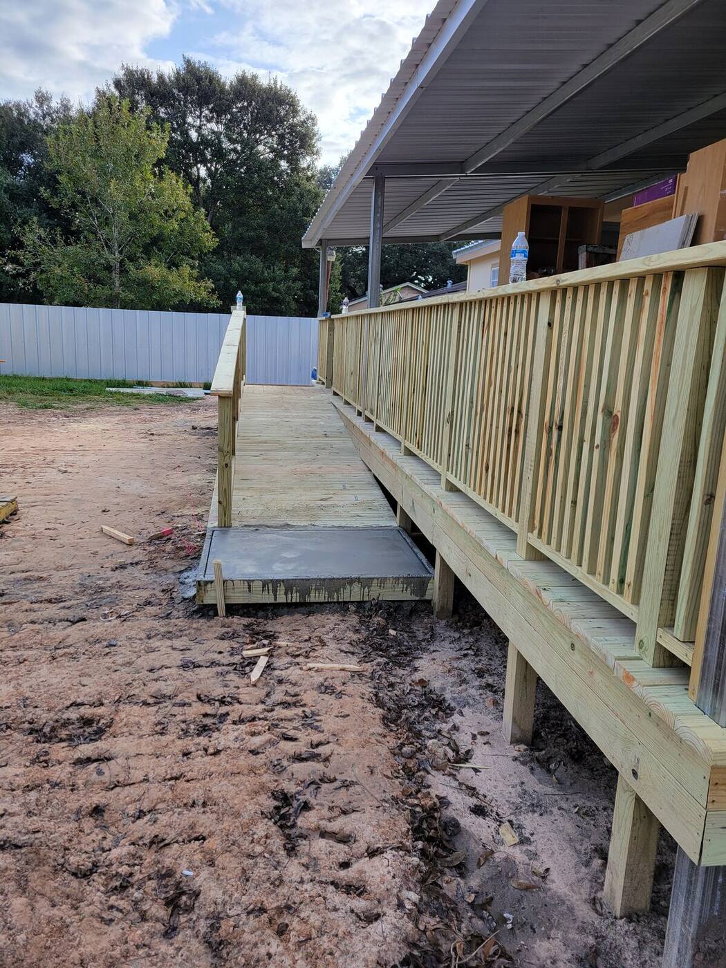 Wood accessibility ramp with handrails along house