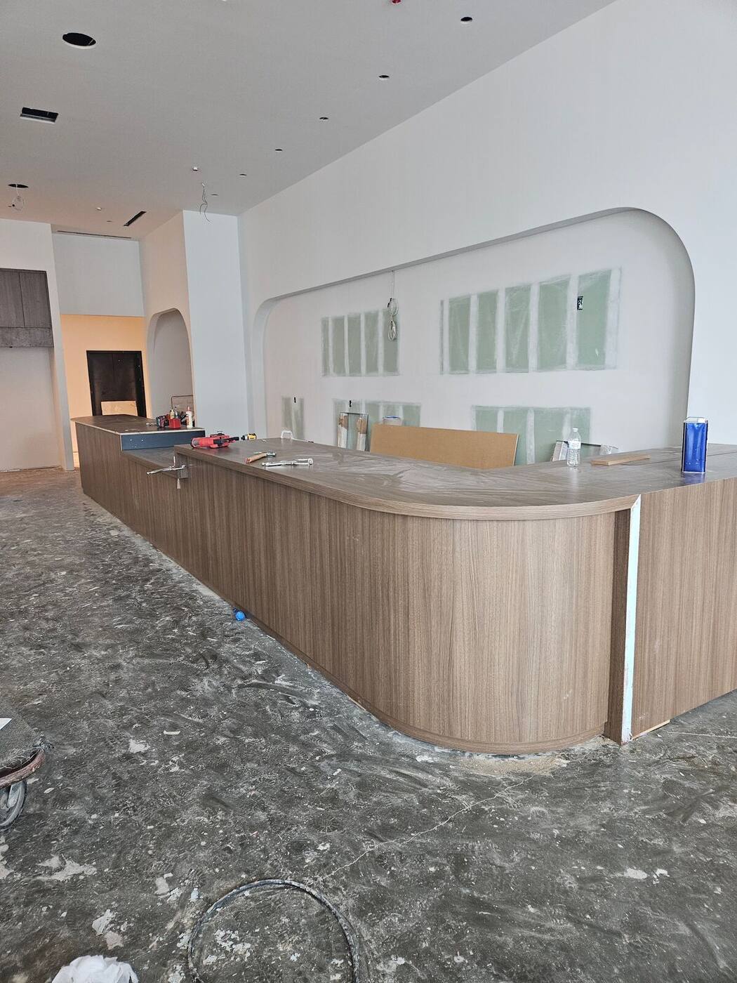 Curved wood reception desk during construction