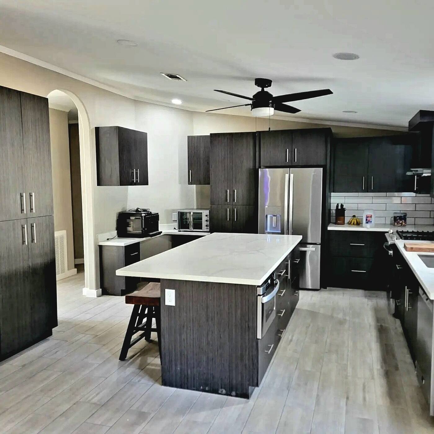 Modern kitchen with dark textured cabinets and white quartz island