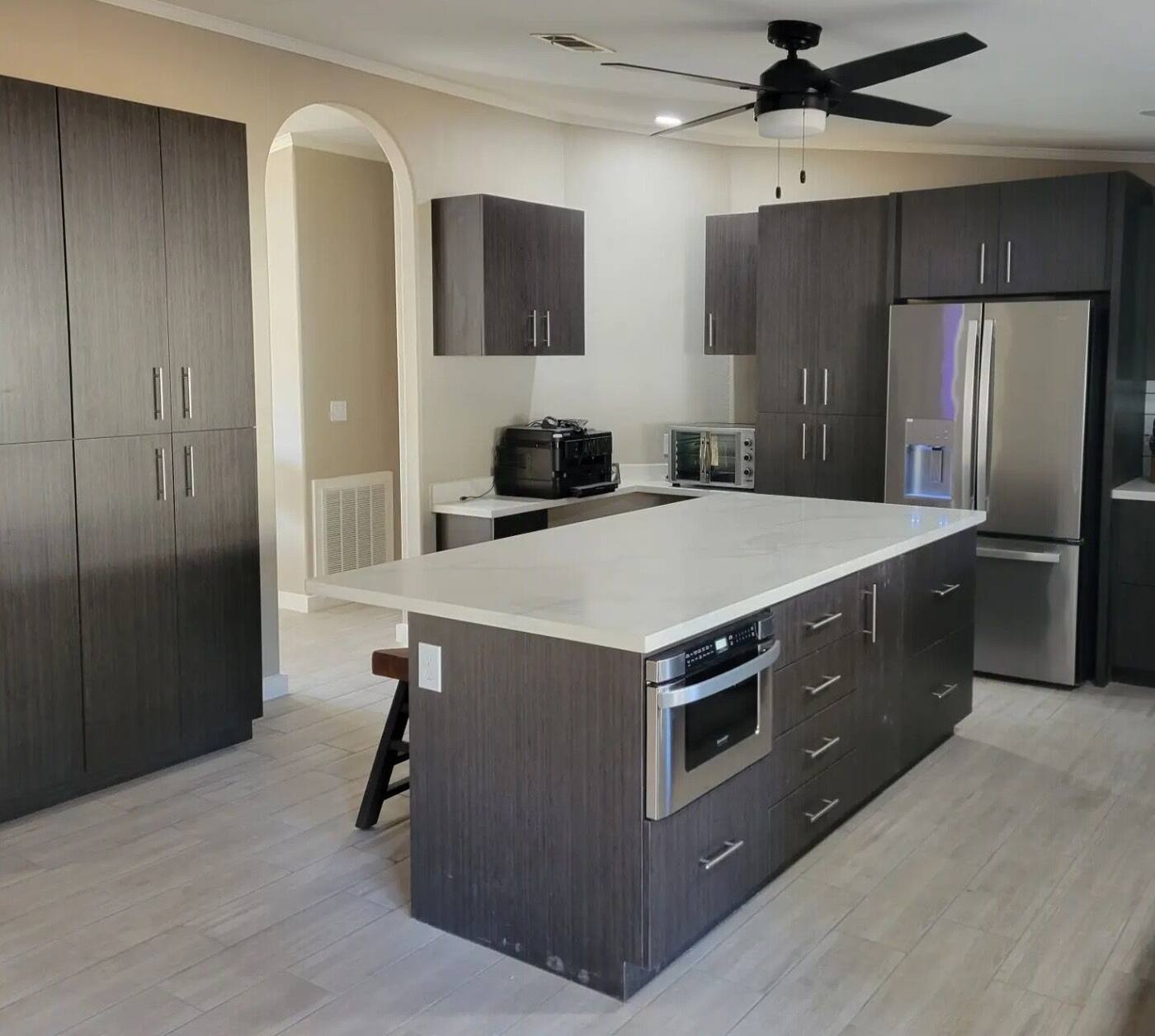Dark kitchen cabinets with built-in fridge and oven tower