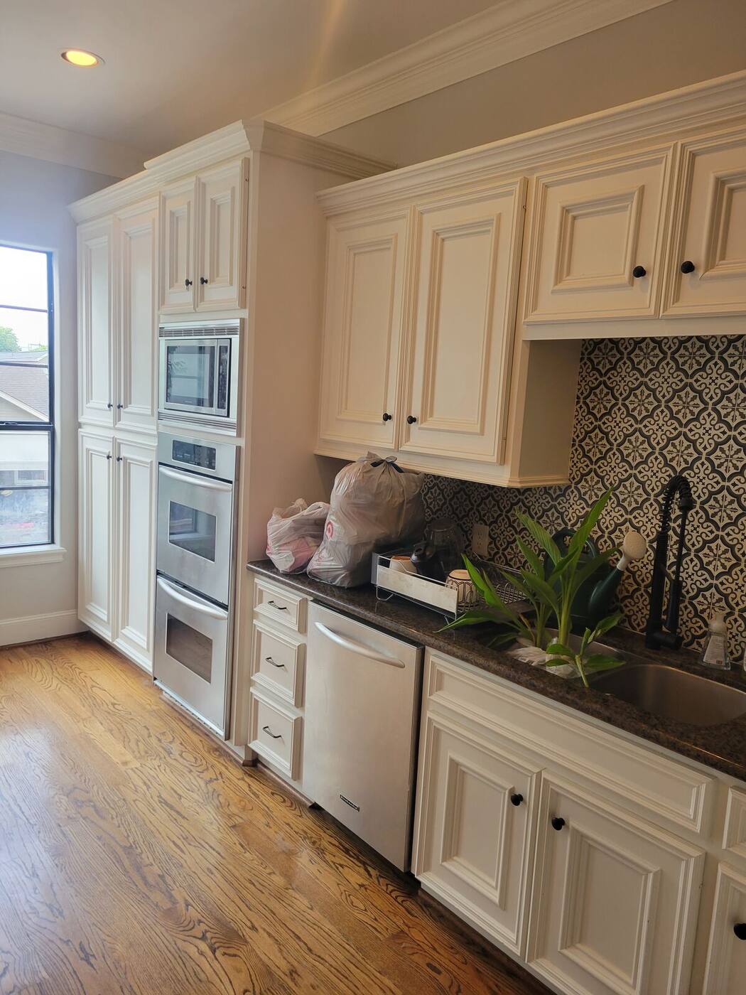 Traditional cream glazed kitchen cabinets with dark countertop