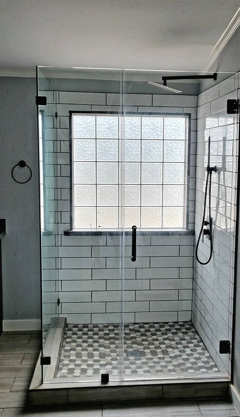 Renovated shower with frameless glass, subway tile and mosaic floor