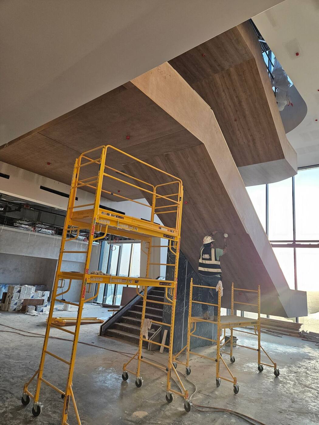 Same staircase during wood wrapping with scaffolding